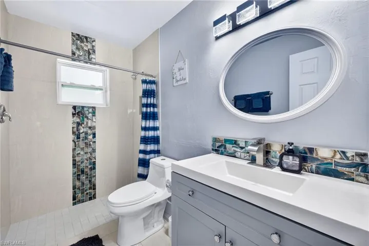 Bathroom featuring vanity, a shower stall, and a textured wall