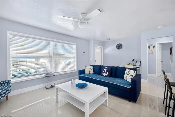 Living area with light tile patterned floors and a ceiling fan