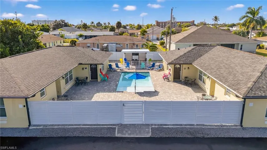 Rear view of house featuring a residential view, a fenced backyard, a community pool, and stucco siding