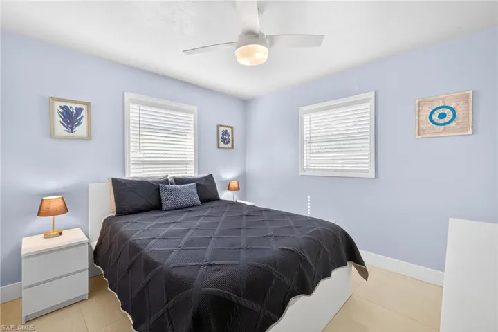 Bedroom with a ceiling fan and light tile patterned flooring