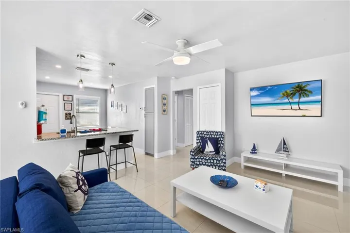 Living area with ceiling fan and light tile patterned flooring