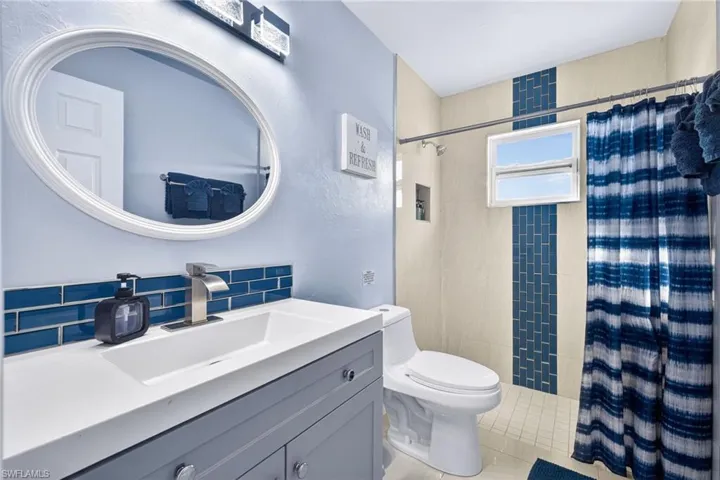 Bathroom featuring a stall shower, vanity, tile patterned flooring, and a textured wall