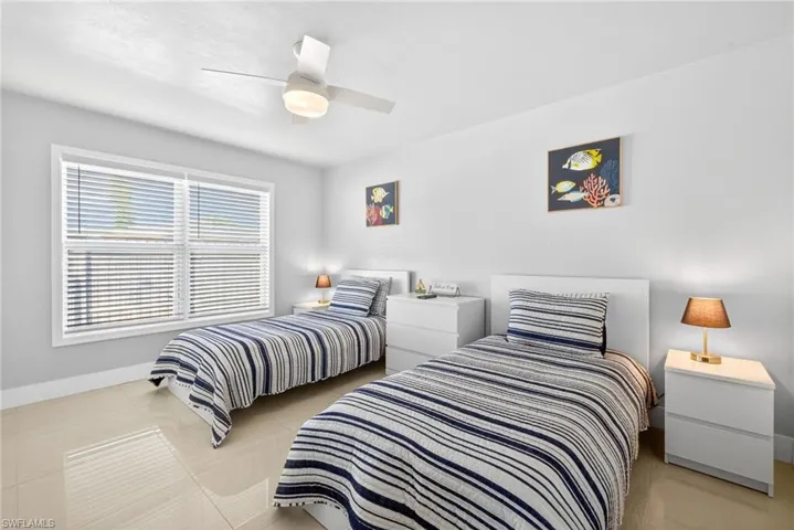 Bedroom with light tile patterned floors and ceiling fan