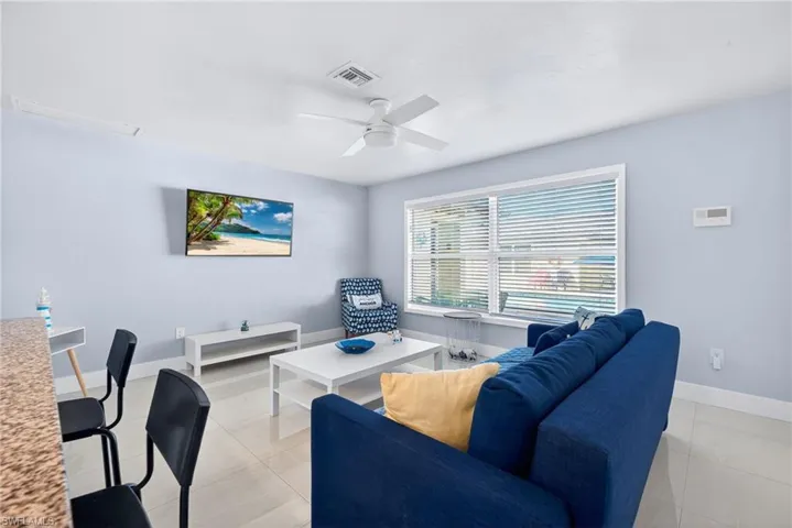 Living area featuring a ceiling fan and light tile patterned floors