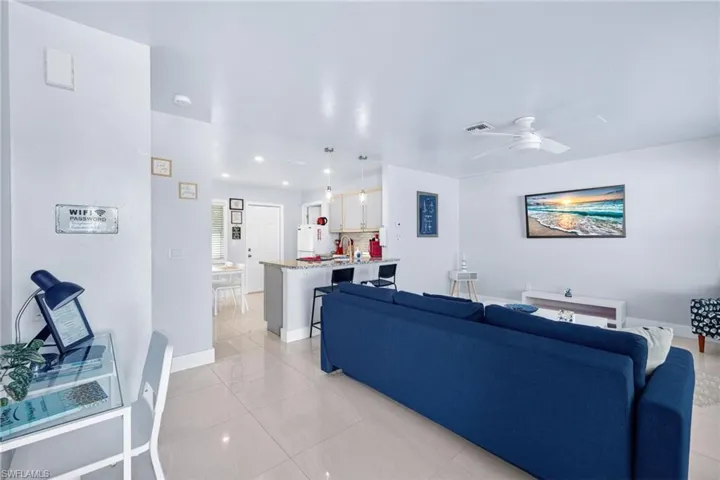 Living area featuring a ceiling fan and light tile patterned floors