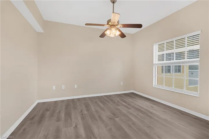 Spare room featuring a ceiling fan, baseboards, and wood finished floors