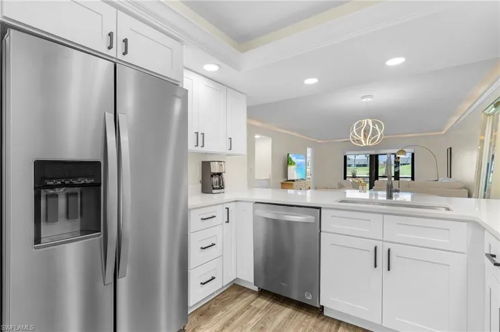 Kitchen with white cabinetry, ornamental molding