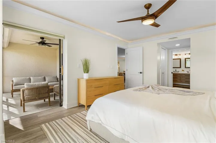 Master Bedroom featuring LVT flooring, ornamental molding, and ceiling fan