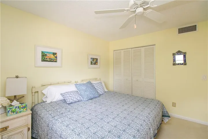 Carpeted bedroom featuring a closet and ceiling fan
