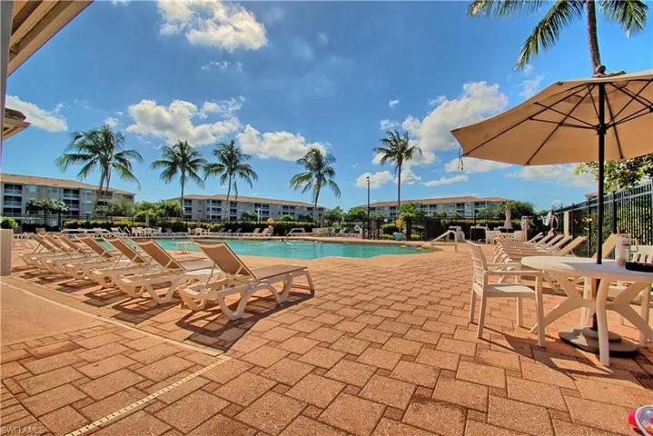 Expansive paved pool deck featuring a geometric swimming pool