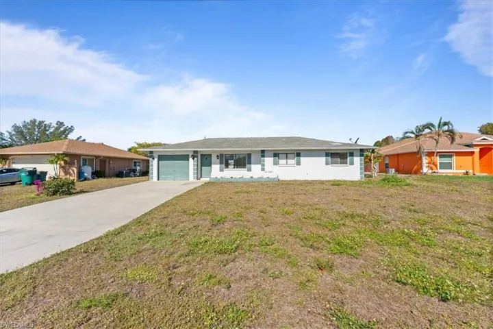 Ranch-style house with an attached garage, a front lawn, and concrete driveway