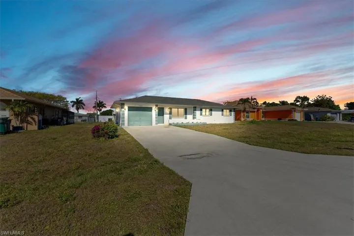 Manufactured / mobile home with a garage, driveway, and a front yard