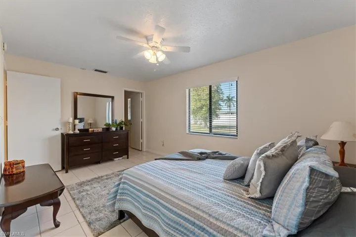 Bedroom with a ceiling fan, visible vents, and light tile patterned floors