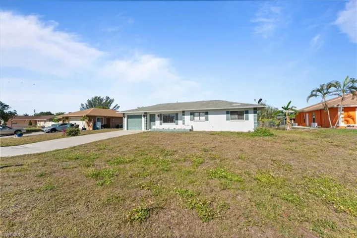 Single story home with an attached garage, driveway, and a front lawn