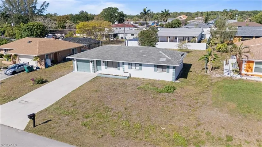 Single story home with concrete driveway, a front lawn, a residential view, and an attached garage
