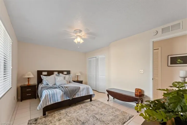 Bedroom featuring a ceiling fan, visible vents, a closet, and light tile patterned floors