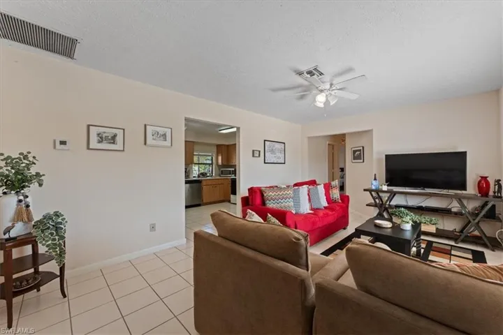 Living area featuring ceiling fan, baseboards, visible vents, and light tile patterned floors
