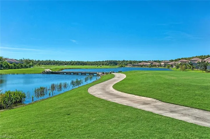 Surrounding community with a lawn and a water view