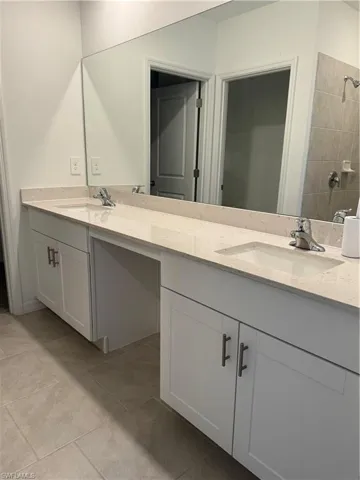 downstairs Bathroom featuring tile patterned floors and double sink vanity