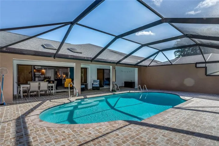 Swimming pool featuring large sitting area with TV and a BEAUTIFUL NEWLY RESURFACED AND TILED POOL area for swimming or sunbathing!!