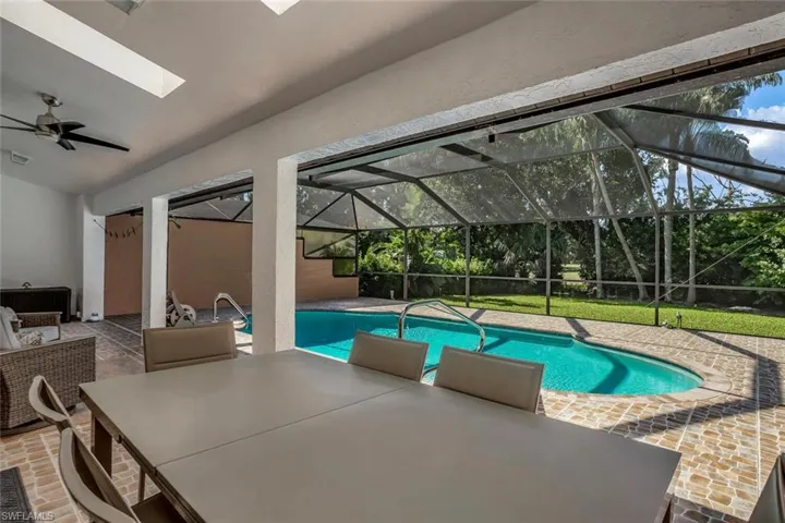 View of swimming pool with a patio area, a lanai, and ceiling fan