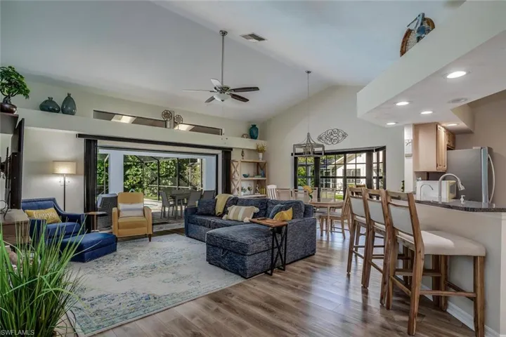 Living room with high vaulted ceiling, ceiling fan, and LPV