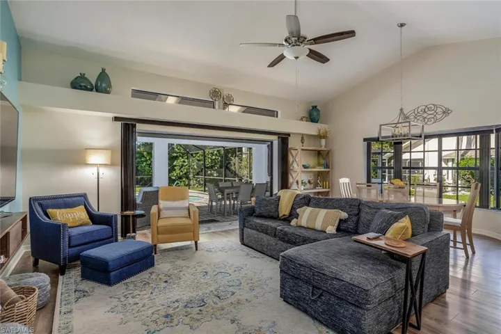 Living room featuring high vaulted ceiling opens up to pool lanai.
