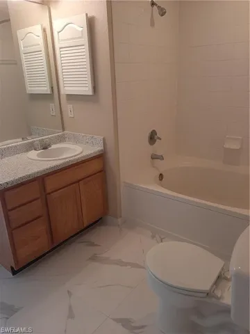 Full bathroom featuring vanity, toilet, and tiled shower / bath