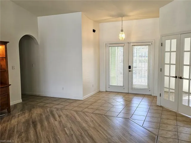 Doorway featuring french doors, arched walkways, and wood finished floors