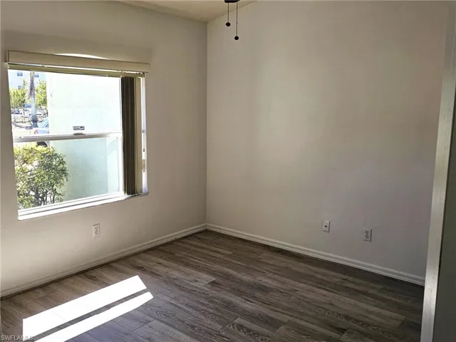 Spare room with dark wood-style floors and a ceiling fan