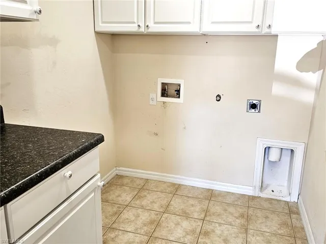 Laundry area with cabinet space, washer hookup, light tile patterned floors, hookup for an electric dryer, and gas dryer hookup