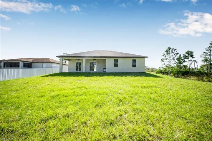 Prairie-style home featuring stucco siding, a front yard, an attached garage, and concrete driveway