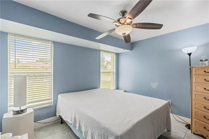 Tiled bedroom featuring ceiling fan
