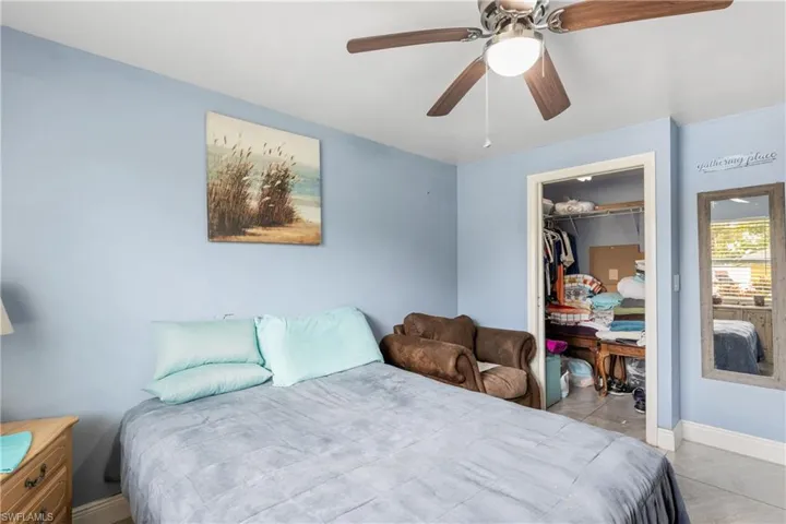 Bedroom featuring a closet, light tile patterned floors, and ceiling fan