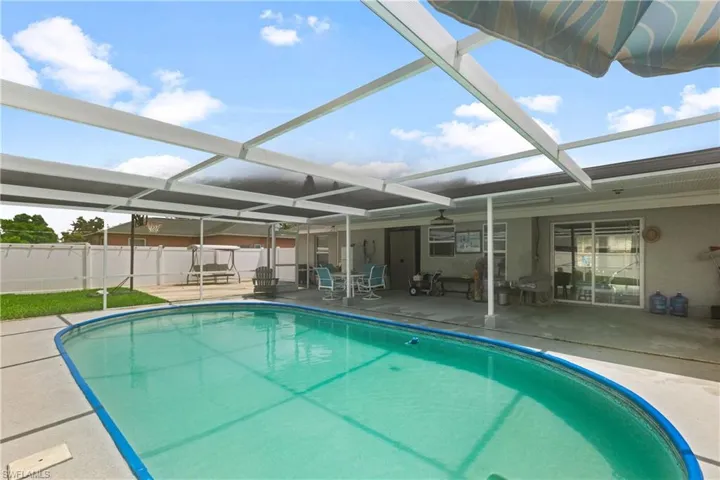 View of pool with a patio and glass enclosure