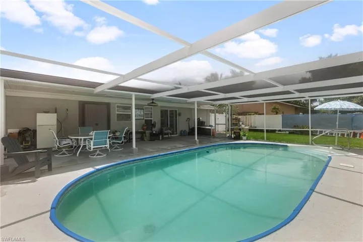 View of swimming pool featuring a patio and a lanai