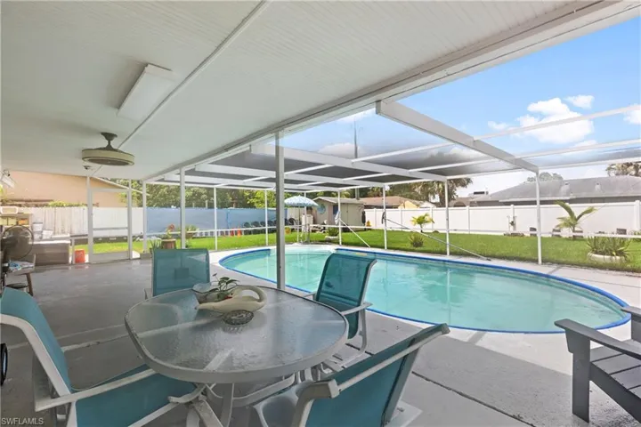 View of swimming pool featuring a lanai, a patio, and a lawn