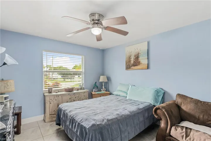 Bedroom with light tile patterned flooring and ceiling fan