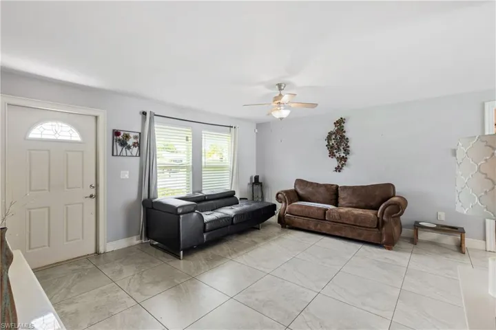 Living room featuring ceiling fan and light tile patterned floors