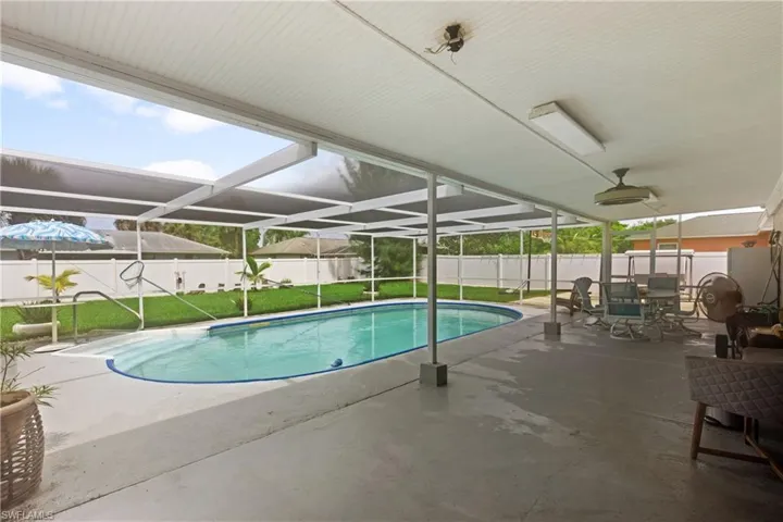 View of pool with a patio, a yard, and glass enclosure