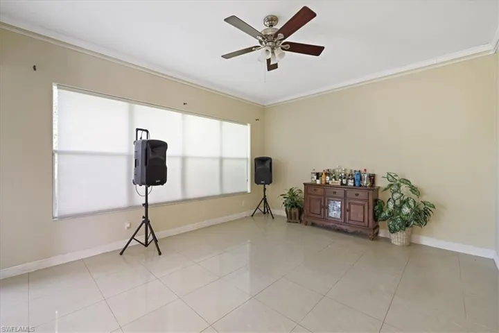 Spare room with ornamental molding, a ceiling fan, and light tile patterned floors