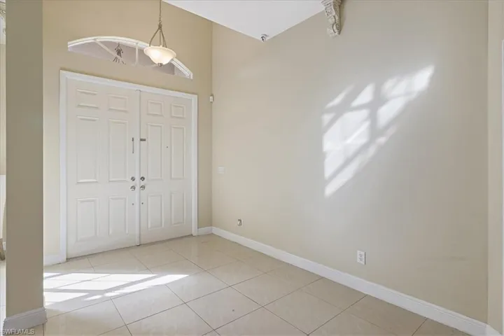 Entrance foyer with light tile patterned floors and baseboards