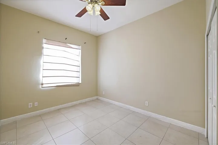 Spare room with ceiling fan and light tile patterned flooring