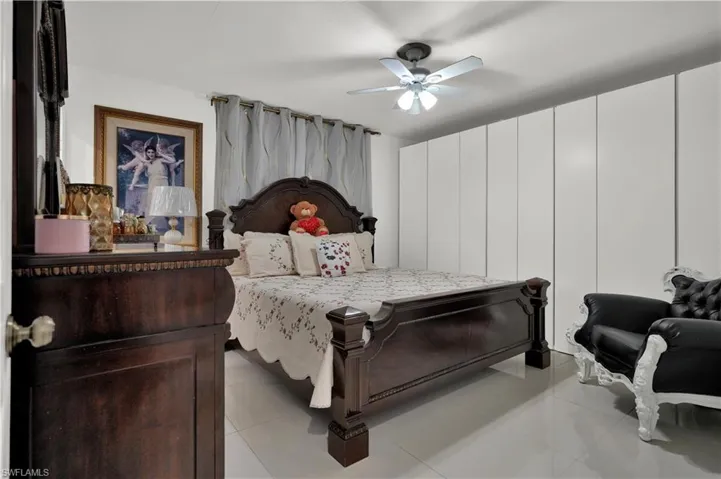 Tiled bedroom featuring ceiling fan