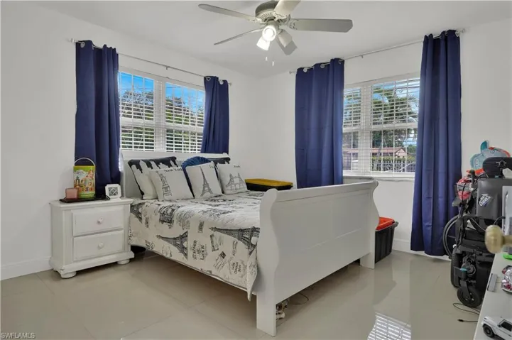 Bedroom featuring multiple windows, ceiling fan, and light tile patterned floors