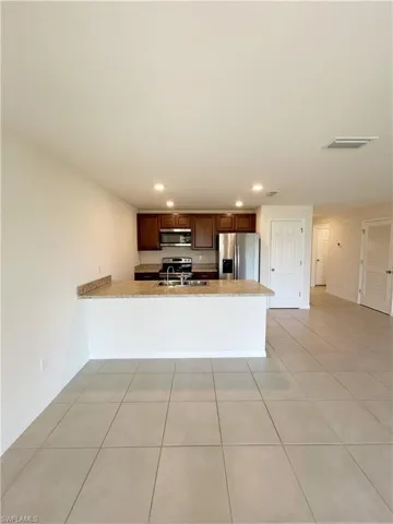 Kitchen with visible vents, recessed lighting, stainless steel appliances, a peninsula, and light tile patterned floors