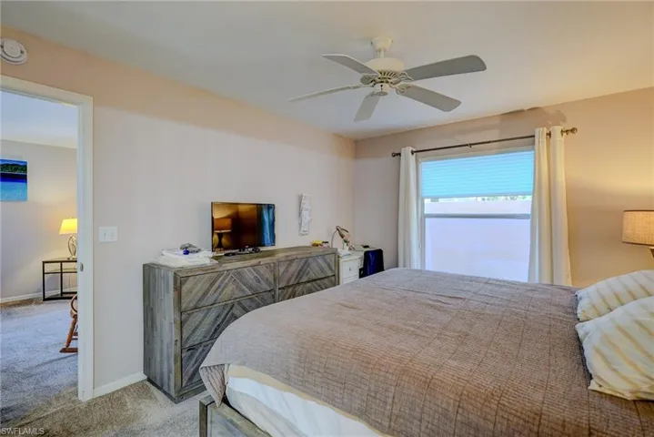 Bedroom featuring carpet floors, baseboards, and ceiling fan