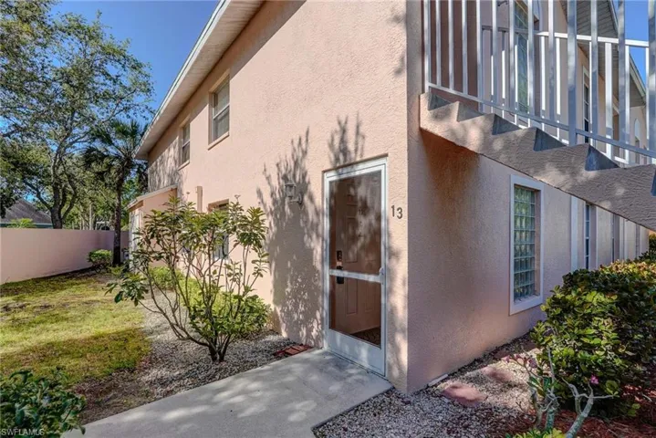 View of property exterior with stucco siding and fence