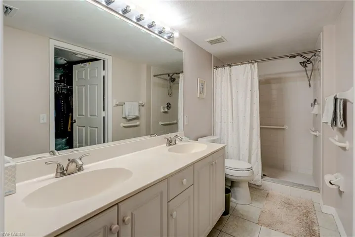 Bathroom with visible vents, a sink, and a stall shower