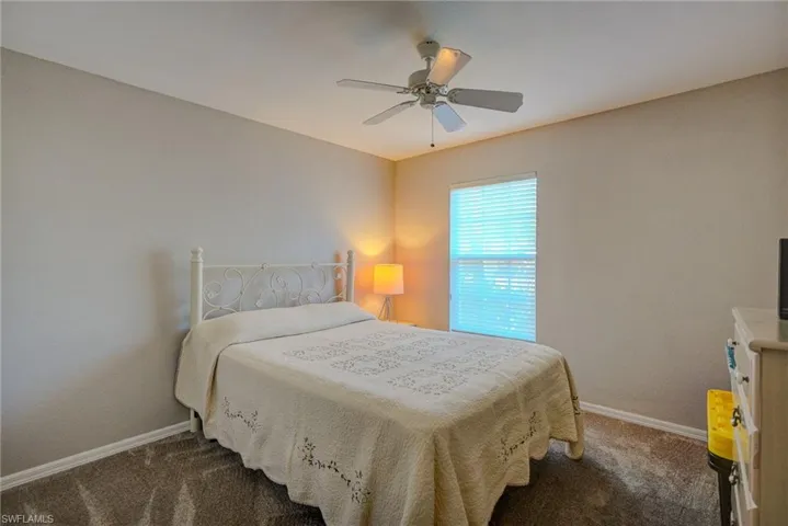 Bedroom with baseboards, carpet, and ceiling fan